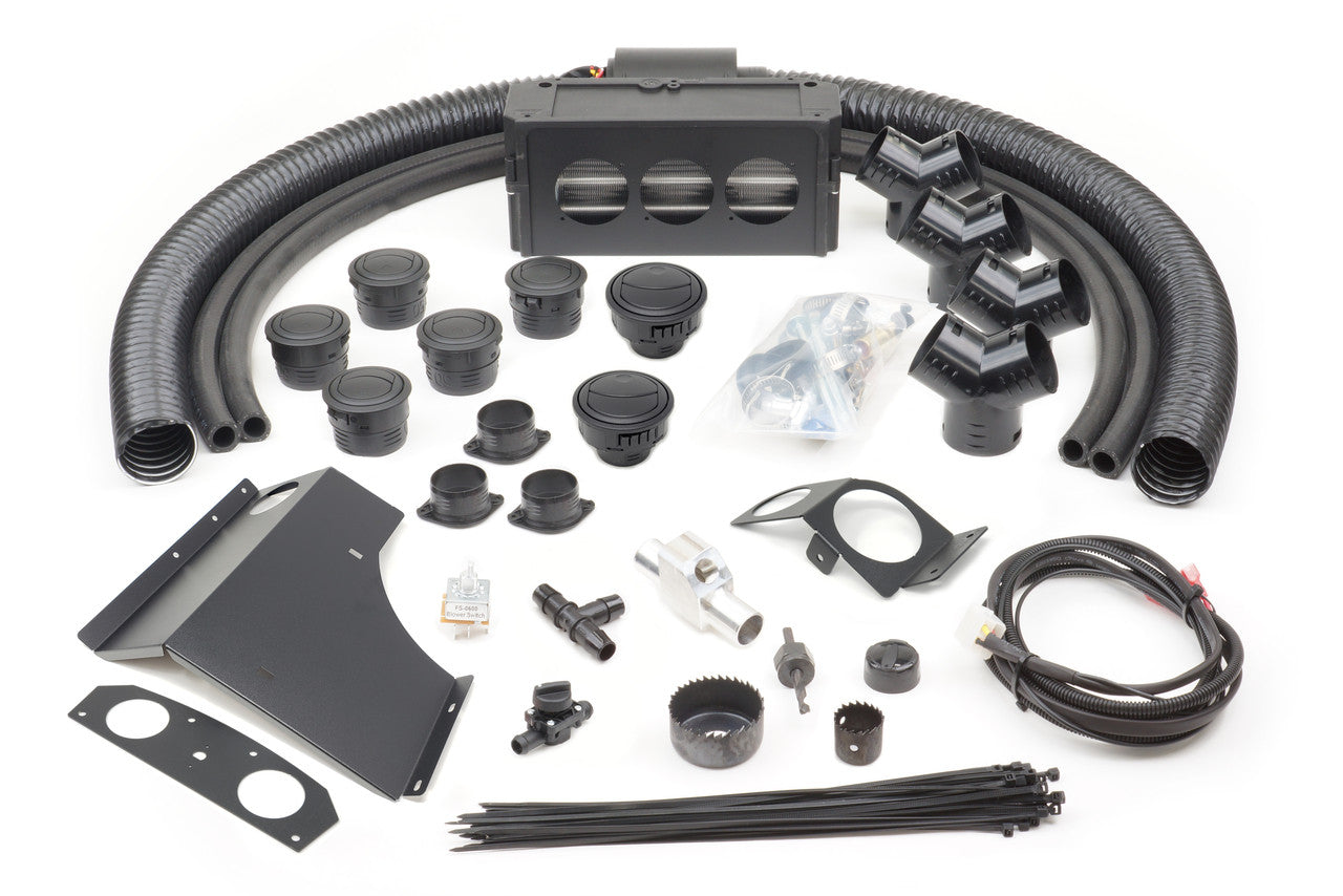 A neatly arranged Can-Am Commander 800 (2009-2020) Ice Crusher Cab Heater kit, featuring hoses, vents, connectors, brackets, wiring, zip ties, fittings, a relay, hole saws, and a black air distribution unit on a white background.