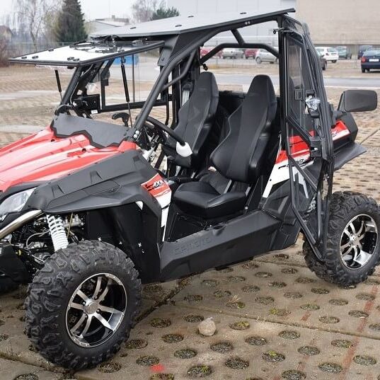 A Full Hard Cab Enclosure by Hard Cabs is installed on a red and black 2015–current CF Moto Zforce 500/800/800EX/1000 utility vehicle with two seats, rugged tires, and a roll cage, parked with open doors on a paved surface.
